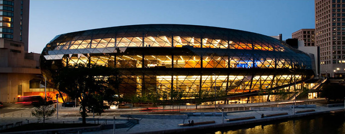 The nighttime photo of the backlit 4 storey interior of the fully glazed exterior of the Ottawa Convention Centre (a.k.a The Shaw Centre), taken from across the Rideau Canal.